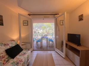 圣艾格夫Studio cabine avec piscine, tennis et parking à 400m de la plage - 4 couchages, Saint-Aygulf - FR-1-226A-89的带沙发的客厅和带桌子的阳台。