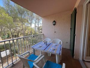 圣艾格夫Studio cabine avec piscine, tennis et parking à 400m de la plage - 4 couchages, Saint-Aygulf - FR-1-226A-89的阳台上配有蓝色的桌椅