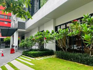 吉隆坡Chamber Services Suite KLCC的前面有树木和植物的建筑