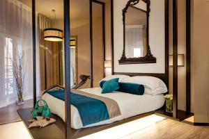 罗马达摩奢华酒店的一间卧室配有一张带镜子的床