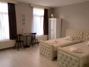 布鲁塞尔信誉公寓的酒店客房带两张床、一张桌子和一间餐厅