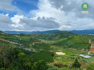 大叻Midori Coffee Farm的享有山谷的空中景色,包括山脉和森林