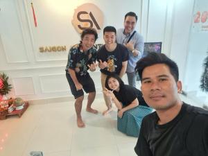 胡志明市Saigon Authentic Hostel - Cozy Rooftop, Family Cooking Experience, FREE Walking Tour, Vietnamese Breakfast & Gym的一群人在一个房间里摆着一张照片