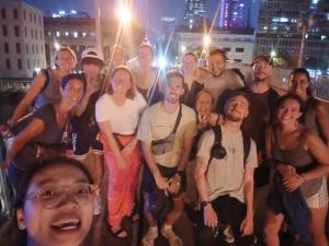 胡志明市Saigon Authentic Hostel - Cozy Rooftop, Family Cooking Experience, FREE Walking Tour, Vietnamese Breakfast & Gym的一群人晚上要拍照