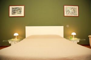 米兰拜罗卡尔独立公寓的一间卧室配有一张带两盏灯的大型白色床。