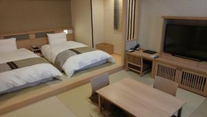 境港市御宿町诺诺酒店的酒店客房设有两张床和一台平面电视。