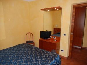 蒙泰罗通多阿尔伯格莱尼酒店的一间卧室配有一张床、一张书桌和一面镜子