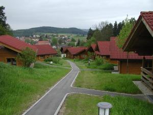 StamsriedBlockhaus Bayerischer Wald的一条 ⁇ 曲的道路穿过一个拥有木屋的村庄