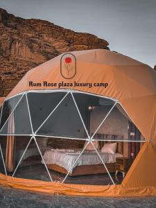 瓦迪拉姆RUM ROSE PLAZA lUXURY CAMP的橙色帐篷,水中配有一张床