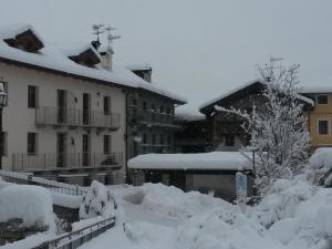 DouesCasa Elisa的一座被雪覆盖的庭院,其背景是建筑