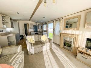 亨斯坦顿Beautiful Caravan At Manor Park Nearby Hunstanton Beach Ref 23030W的带沙发和壁炉的客厅