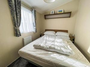 大雅茅斯Lovely 6 Berth, Dog Friendly Caravan For Hire In Norfolk Ref 50011Ae的卧室内的一张带白色床单和枕头的床