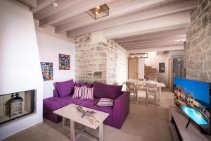 SívasPhaistos Villas的客厅配有紫色沙发和电视