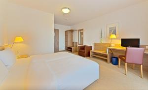 巴特塞京根Sapia Hotel St. Fridolin的卧室配有一张白色大床和一张书桌