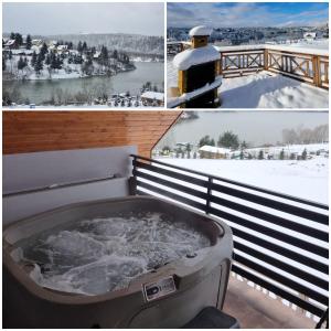 扎沃兹Domki Na Wzgórzu Słońce JACUZZI SAUNA ROWERY的雪地阳台的热水浴池