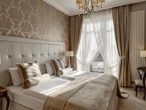 希隆斯克地区佩卡雷比托姆豪华住宅酒店的一间卧室配有一张大床和一个吊灯。