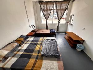 乌鲁地南Jiaxin Dormitory - Puteri Wangsa 家馨旅舍的一间卧室设有两张床和窗户。