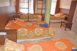 图皮萨米特鲁酒店的带3张床和橙色床单的客房