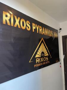 开罗Rixsos Pyramids Inn的墙上有红 ⁇ 象征物的标志