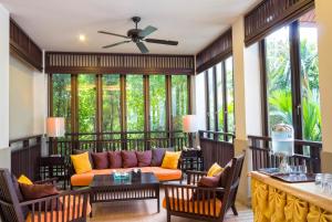 乌隆他尼班雅度假酒店 的客厅配有沙发、桌子和窗户