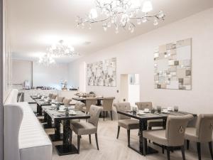尚佩里Hôtel Le White - Le 42 Restaurant的一间带桌椅和吊灯的用餐室