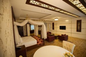 迪亚巴克尔米坦尼丽晶酒店的一间卧室设有一张床和一间客厅。