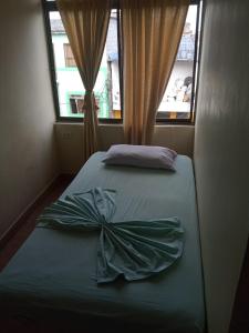 阿西斯港Hostal SAN JOSE PLAZA - TAYRONA 1的一间卧室,配有一张床,床上有一个弓