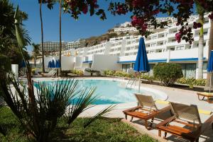 波多黎各埃尔格列柯酒店的一个带两把椅子的游泳池和一间酒店
