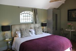 StanleyHayeswood Lodge Luxury Accommodation的一间卧室配有一张大床和紫色毯子
