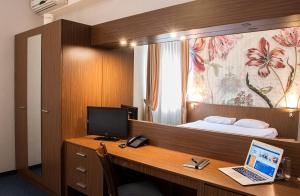 索非亚DITER Family Hotel的客房设有一张带笔记本电脑和一张床的书桌