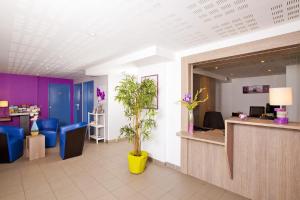 马诺斯克Apparthotel Séjours & Affaires Manosque的大堂设有蓝色和紫色的等候区