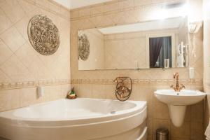 布达佩斯布达佩斯棉花楼酒店的浴室配有白色浴缸和水槽