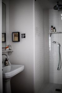 巴黎Le Pigalle, a Member of Design Hotels的带淋浴和盥洗盆的白色浴室