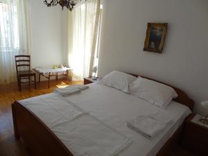 赫瓦尔Inn Town Center的一间卧室配有一张带白色床单和椅子的床