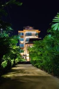 华欣VISA Hotel Hua Hin - SHA Plus的前方有一条路在晚上的建筑