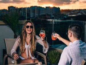 姆西达Aparthotel Adagio Malta Central的戴着酒杯的男人和女人