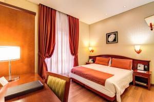 罗马奥古斯塔鲁西拉宫酒店的酒店客房配有一张床、一张书桌
