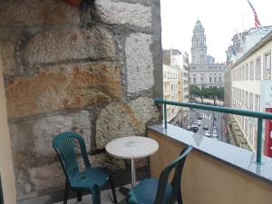 波尔图波尔图黎各宾馆的市景阳台配有桌椅