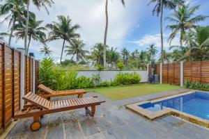 迪克韦勒Kaas Villas - Entire Two Bedroom Villa With Private Pool & Garden的一个带2个长椅和游泳池的庭院