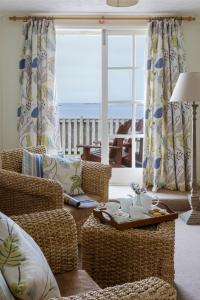 Hugh Town星级城堡酒店的客厅配有椅子、桌子和窗户