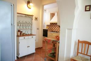 奥里亚Il Casolare Degli Ulivi的厨房配有桌子和白色冰箱。