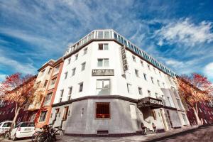 杜塞尔多夫Boutique Hotel Düsseldorf Berial的白色的建筑,旁边标有标志