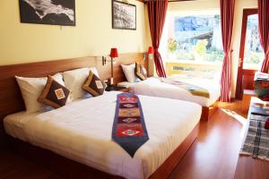 萨帕萨帕黄龙酒店的酒店客房设有两张床和窗户。