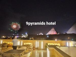 开罗9pyramids hotel的站在一座烟花建筑顶端的人