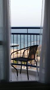 亚实基伦Avrora Luxury Apartment的一个带椅子和桌子的阳台,享有海景。