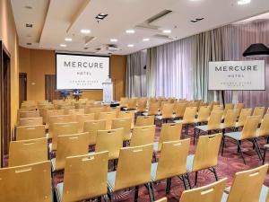 格但斯克Mercure Gdańsk Stare Miasto的一个带椅子和讲台的会议室