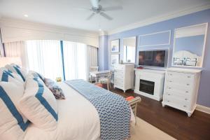 查尔斯顿查尔斯顿港海滩俱乐部度假村的一间卧室配有一张床、一台电视和一个梳妆台