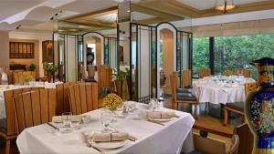 孟买海洋广场酒店的餐厅设有白色的桌椅和大镜子