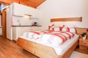新波南特Alps Residence的一间卧室配有一张带红色和白色枕头的木床。