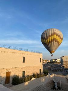 乌奇希萨尔Cappadocia Chiaro的飞过大楼的热气球